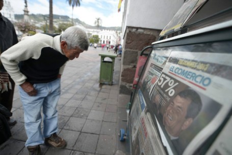 Homem lê capa de jornal sobre a reeleição do presidente Rafael Correa em Quito, em 2013 /  Folha de S. Paulo