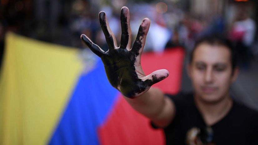 A protester shows his black-painted hand as he carries an Ecuador flag to protest against Chevron and the oil contamination in Ecuador's Amazon region during a demonstration in Madrid, Spain, in 2013. Ecuador was awarded a $19 billion judgment for damages in 2013, but that was subsequently overturned due to illegal activity by the plaintiffs' U.S.-based attorney. Photo: Investor's Business Daily