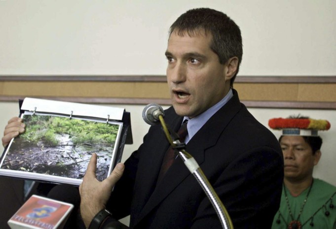Attorney Steven Donziger shows pictures of a pool of oil which seeped out from an oil waste pit left behind by Texaco at an oil pump site in the Amazon jungle, in Quito, in this October 30, 2003 file photo.  Foto: Yahoo Finance